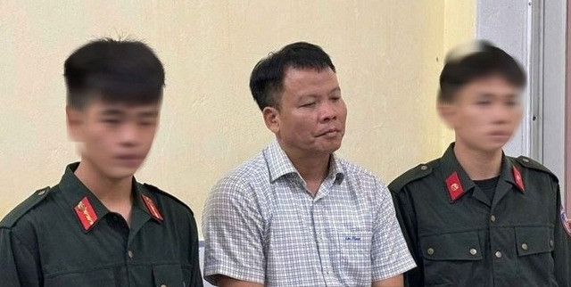 Ông Đồng Xuân Thụ, Tổng biên tập Tạp chí Môi trường và Đô thị Việt Nam (giữa), bị giữ khẩn cấp về tội cưỡng đoạt tài sản