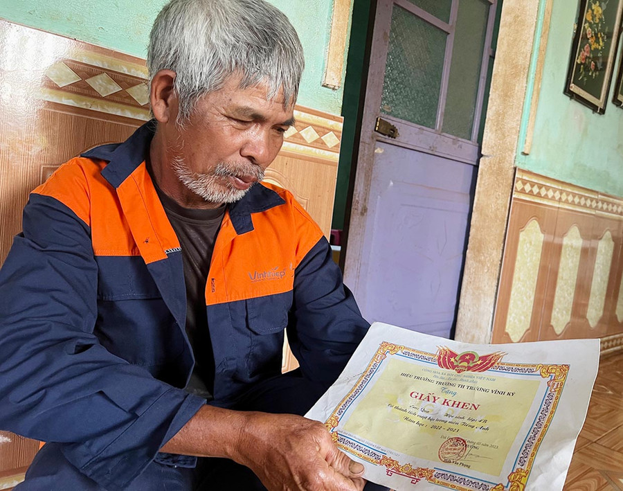 Ông Tuing khoe thành tích học tập của con gái nuôi. Ảnh: T.H Ông Tuing khoe thành tích học tập của con gái nuôi. Ảnh: T.H