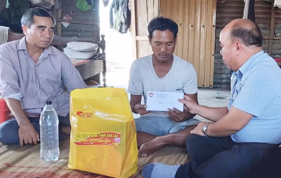 Ông siu Trung-Phó Chủ tịch Ủy ban MTTQ Việt Nam tỉnh (bìa phải) tặng quà cho gia đình anh Siu Thoan là hộ nghèo tại xã Ia Piar. Ảnh: Ngọc Anh