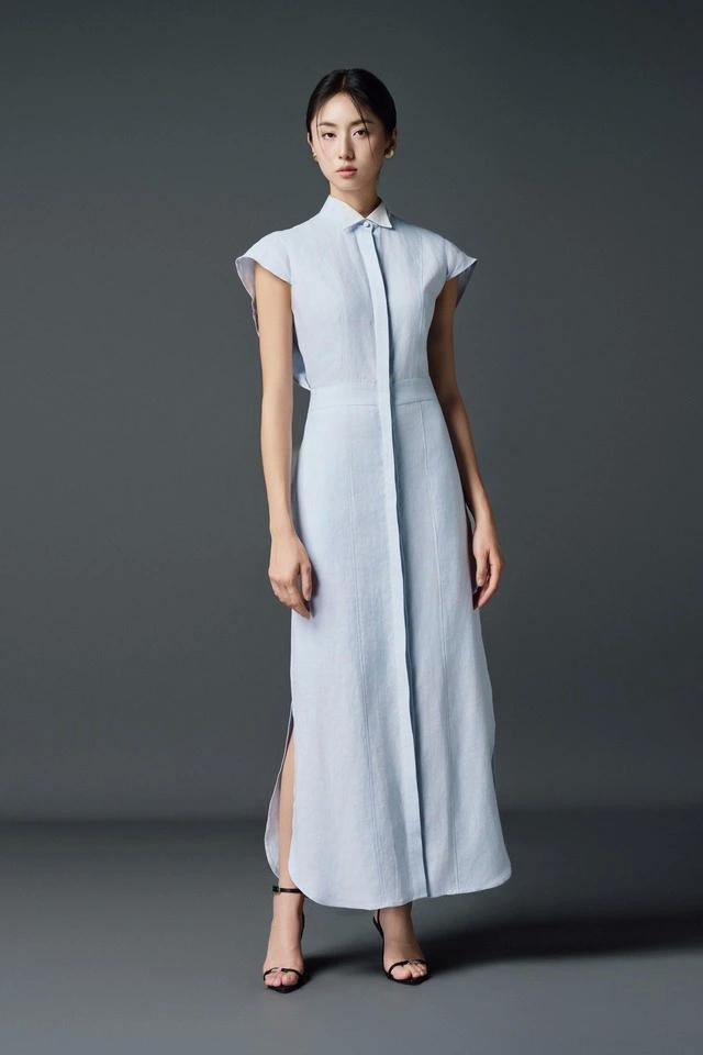 Váy sơ mi dáng dài lấy cảm hứng từ phom dáng của chiếc áo sơ mi không tay tông màu xanh nhạt duyên dáng. Chi tiết nẹp cúc chạy dài từ cổ xuống chân váy tạo nét sắc sảo, kết hợp đường xẻ bên hông khơi gợi trí tò mò của người nhìn ngắm. ẢNH: LYP Váy sơ mi dáng dài lấy cảm hứng từ phom dáng của chiếc áo sơ mi không tay tông màu xanh nhạt duyên dáng. Chi tiết nẹp cúc chạy dài từ cổ xuống chân váy tạo nét sắc sảo, kết hợp đường xẻ bên hông khơi gợi trí tò mò của người nhìn ngắm. ẢNH: LYP