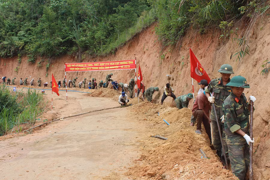 Các cán bộ, chiến sĩ của Lữ đoàn 273 cùng nhân dân đào mương, chôn ống dẫn nước về làng. Ảnh: Vĩnh Hoàng