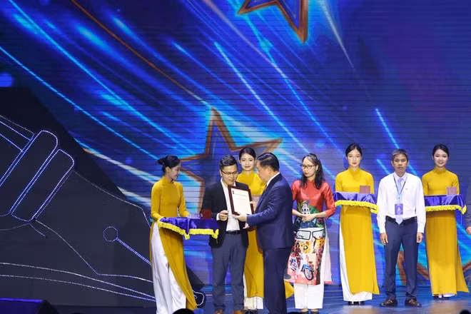 Trưởng Ban Tuyên giáo Trung ương Nguyễn Trọng Nghĩa trao giải A cho tác giả Võ Mạnh Hùng. (Ảnh: Hoài Nam/Vietnam+)