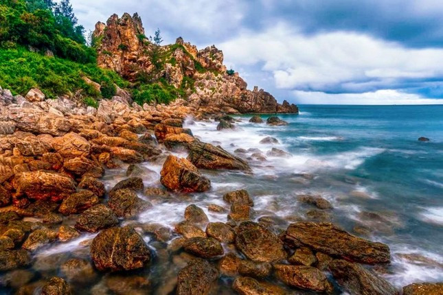 Ngày xưa, học trò khắp nơi thường hay tụ lại đây để lấy loại đá này về làm mực đỏ cho thầy chấm bài nên đến tận bây giờ thì không còn có nhiều loại đá son đỏ này tại Mũi Vi Rồng. Nhưng nếu tỉ mỉ ngắm nhìn thì thỉnh thoảng nhiều khách du lịch vẫn có thể tìm thấy những hòn đá son màu đỏ nằm lẫn trong cát biển. Ảnh: Huỳnh Nguyễn Thành. Ngày xưa, học trò khắp nơi thường hay tụ lại đây để lấy loại đá này về làm mực đỏ cho thầy chấm bài nên đến tận bây giờ thì không còn có nhiều loại đá son đỏ này tại Mũi Vi Rồng. Nhưng nếu tỉ mỉ ngắm nhìn thì thỉnh thoảng nhiều khách du lịch vẫn có thể tìm thấy những hòn đá son màu đỏ nằm lẫn trong cát biển. Ảnh: Huỳnh Nguyễn Thành.