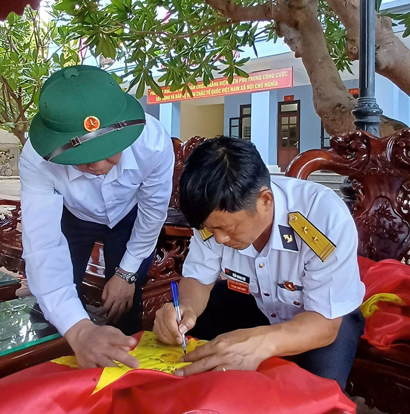 Thượng tá Trần Quang Phú, Chỉ huy trưởng đảo Trường Sa ký tên vào lá cờ. Thượng tá Trần Quang Phú, Chỉ huy trưởng đảo Trường Sa ký tên vào lá cờ.