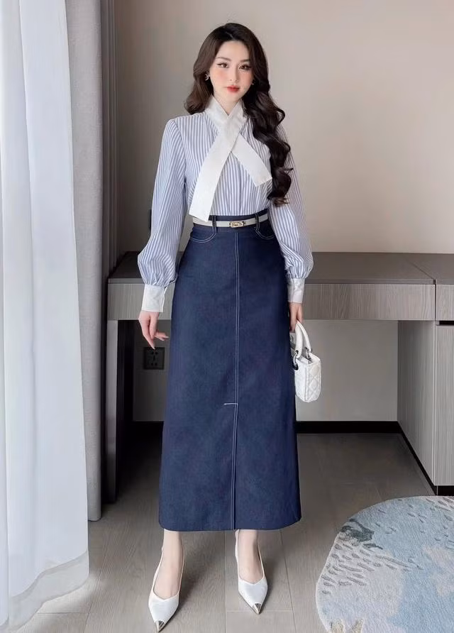 Gợi ý cho nàng set đồ với tông màu xanh mát mắt, xoa dịu nhiệt độ nắng hè oi ả với chất liệu thô mềm mịn và thoáng mát. Sơ mi kết hợp với chân váy jean dáng dài cạp cao, vừa đứng phom lại thoải mái, dễ chịu khi mặc. Đặc biệt họa tiết kẻ ngang còn có tác dụng "đánh lừa" thị giác, giúp vóc dáng thêm cao ráo và thanh thoát hơn