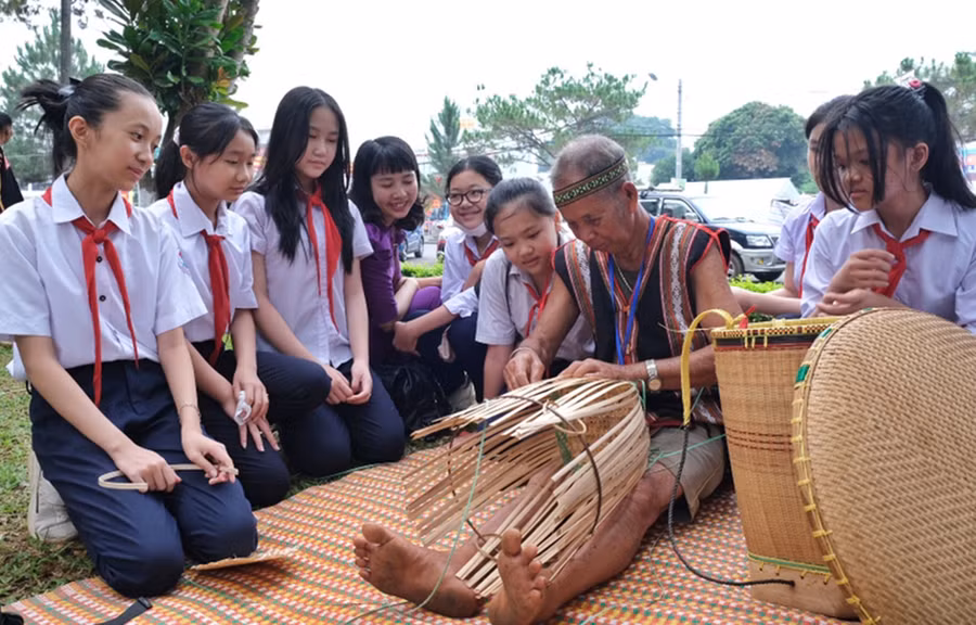 Học sinh Trường THCS Nguyễn Du (TP. Pleiku) thích thú xem nghệ nhân đan lát, làm ra các sản phẩm từ mây, tre.Ảnh: M.C
