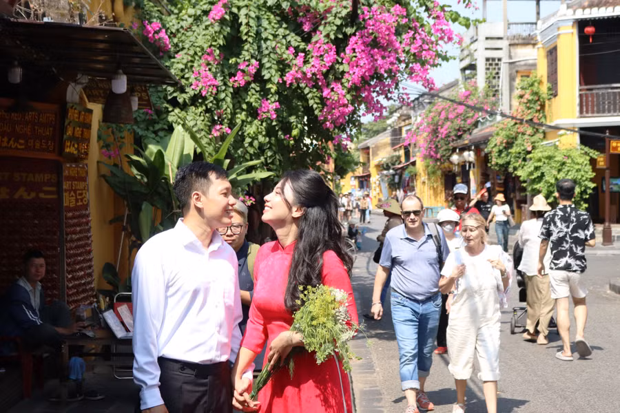 Nhiều cặp đôi tìm về phố cổ Hội An chụp ảnh cưới khi mùa hoa giấy nở rộ. Ảnh: Bảo Duy