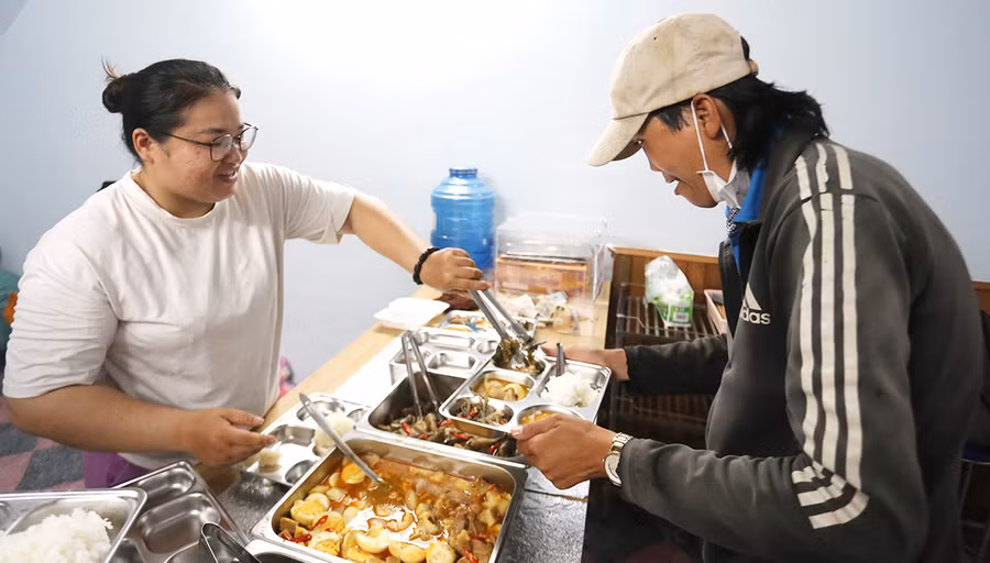 Người nghèo đến ăn cơm ở quán được phục vụ tận tình và tặng 3 gói mì tôm mang về. Ảnh: L.G