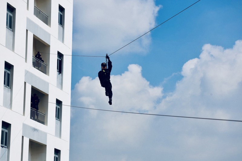 Bài tập đu dây qua các tòa nhà của các nữ chiến sĩ cảnh sát đặc nhiệm. Ảnh: NAM VY Bài tập đu dây qua các tòa nhà của các nữ chiến sĩ cảnh sát đặc nhiệm. Ảnh: NAM VY