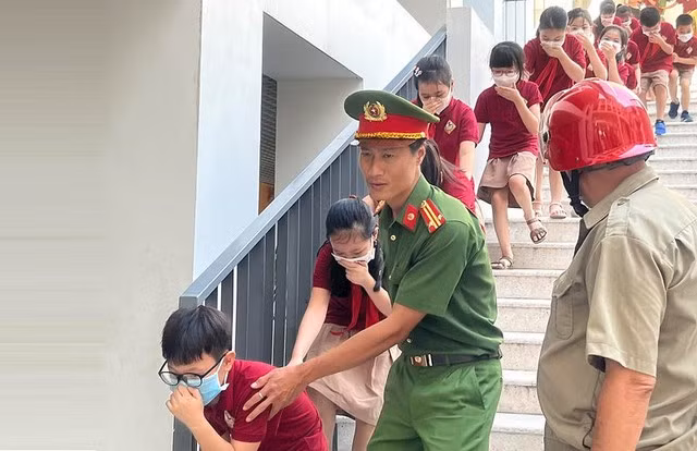 Bộ GD-ĐT yêu cầu trang bị kỹ năng phòng cháy, thoát hiểm cho học sinh - Ảnh 1. Một buổi diễn tập phòng cháy, thoát hiểm cho học sinh tại Q.Đống Đa (Hà Nội) mới đây. Ảnh: H.N