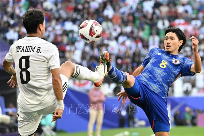 Tiền vệ Ibrahim Bayesh (trái) của Iraq tranh bóng với tiền vệ Takumi Minamino của Nhật Bản. Ảnh: AFP/TTXVN