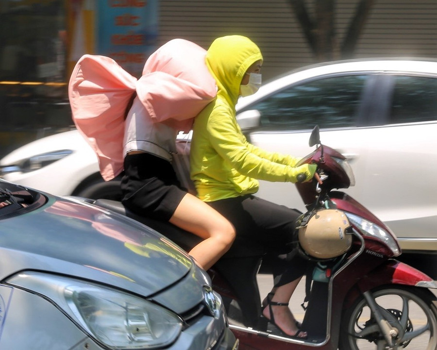 Người dân che chắn chống nắng khi di chuyển ngoài trời. (Ảnh: TTXVN) Người dân che chắn chống nắng khi di chuyển ngoài trời. (Ảnh: TTXVN)