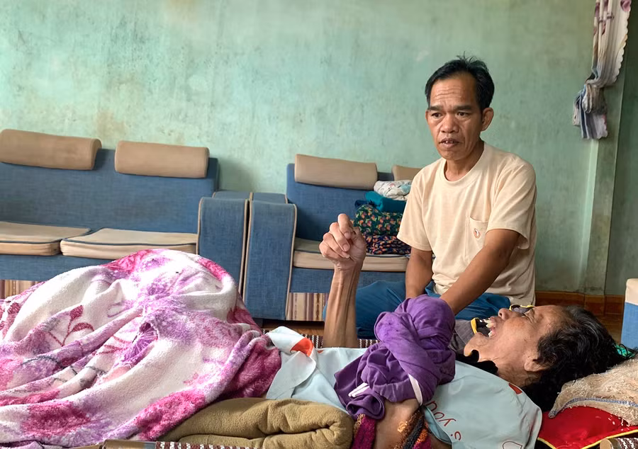 Dù đang mắc bệnh nhưng ông Siu Nam vẫn cố gắng chăm sóc người vợ nằm liệt giường. Ảnh: R.H