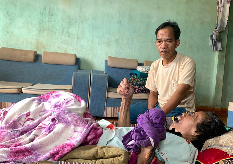 Dù đang mắc bệnh nhưng ông Siu Nam vẫn cố gắng chăm sóc người vợ nằm liệt giường. Ảnh: R.H