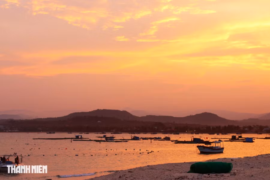 Từ đảo Hòn Chùa nhìn về phía bờ biển xã An Phú. Tàu cá, ca nô chở khách du lịch chạy chưa đến 10 phút thì cập bãi cát của đảo phía đối diện đất liền. Ảnh: TRÍ MINH