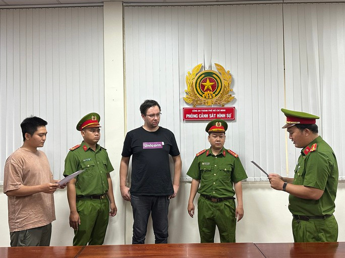 Aigars Plivčs (áo đen) tại cơ quan công an. Aigars Plivčs (áo đen) tại cơ quan công an.