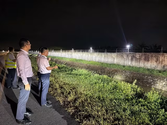 Giám đốc Cảng hàng không quốc tế Nội Bài Tô Tử Hà kiểm tra mương thoát nước. Ảnh: Phan Công