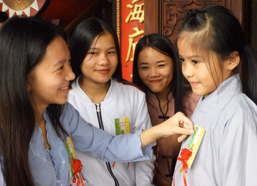 Niềm hạnh phúc của giới trẻ khi được cài hoa hồng đỏ thắm trong dịp Đại lễ Vu Lan. Ảnh: Thanh Nhật