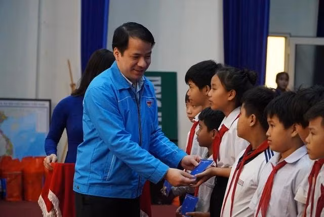 Anh Ngô Văn Cương tặng học bổng cho các học sinh. Ảnh: ĐỨC NHẬT