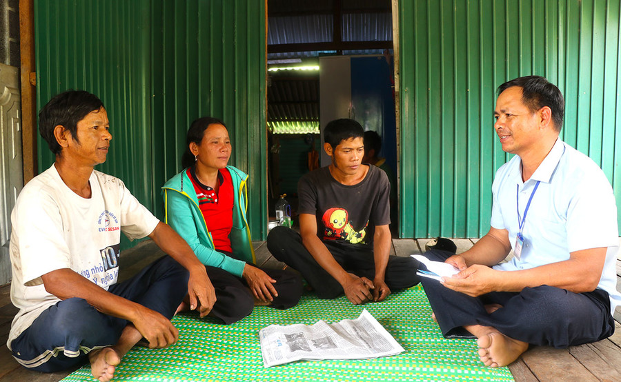 Cán bộ xã Đăk Tơ Pang (bìa phải) đến từng nhà tuyên truyền người dân về ngăn ngừa tình trạng tảo hôn. Ảnh: Ngọc Minh