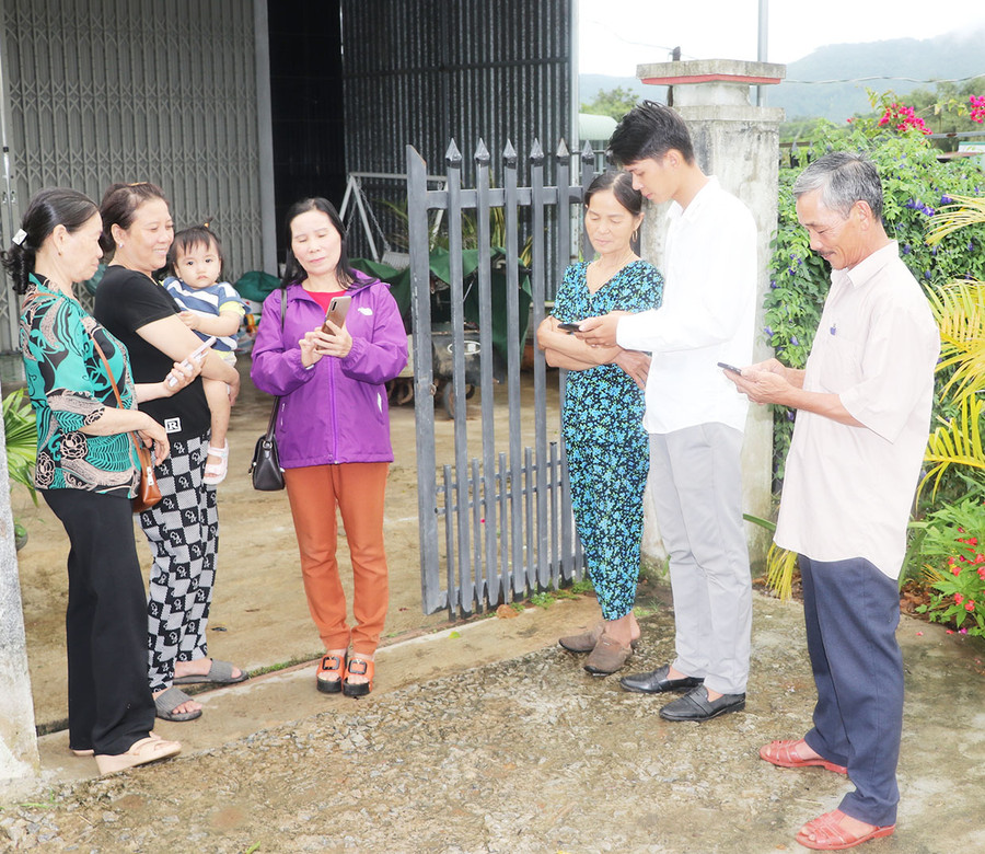 Cán bộ tổ dân phố 4 hướng dẫn người dân tham gia nhóm Zalo để kịp thời nắm bắt thông tin. Ảnh: N.M