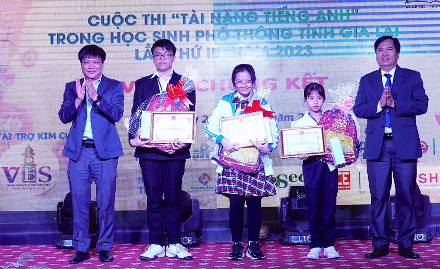 Phó Giám đốc Sở Giáo dục và Đào tạo Trần Bá Công (bìa phải) trao thưởng cho các thí sinh đạt giải nhất. Ảnh: M.T