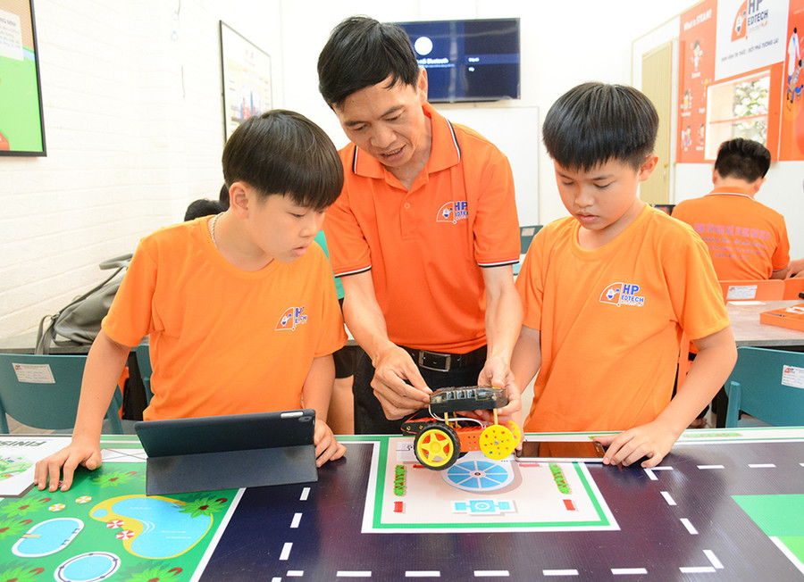 Thầy Nguyễn Thanh Phụng hướng dẫn học sinh tại Trung tâm Ngoại ngữ, Tin học giáo dục HP trong một buổi học về Robotics. Ảnh L.N