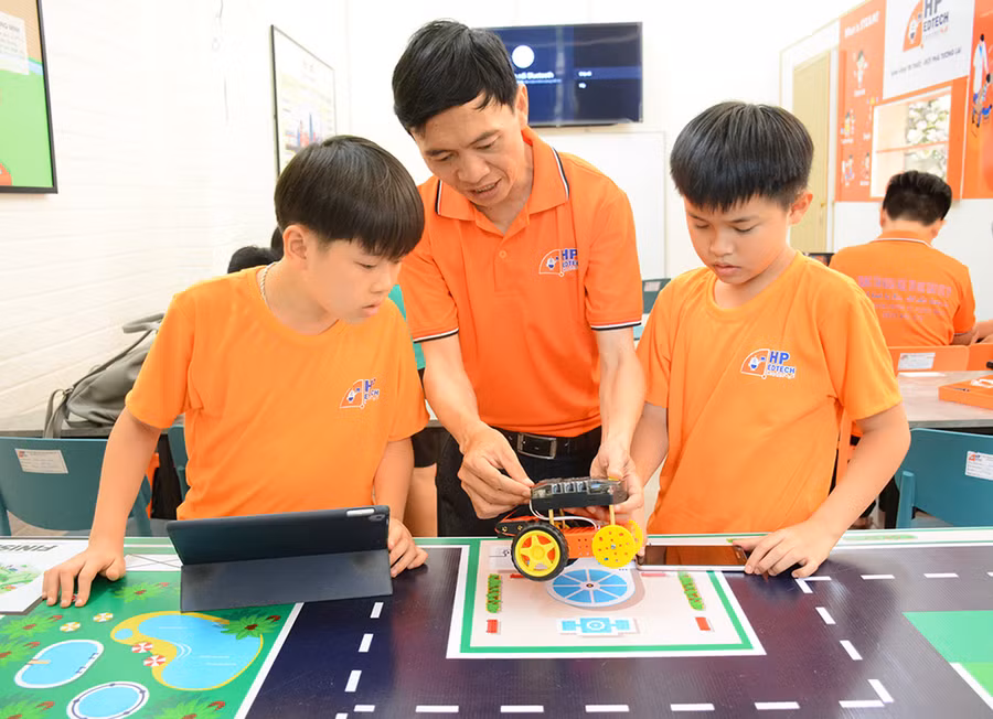 Thầy Nguyễn Thanh Phụng hướng dẫn học sinh tại Trung tâm Ngoại ngữ, Tin học giáo dục HP trong một buổi học về Robotics. Ảnh L.N
