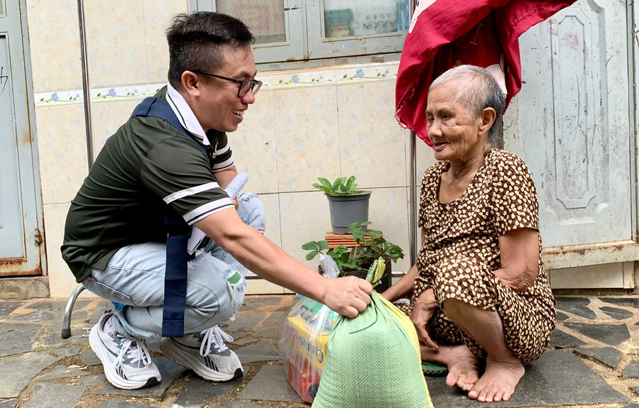 Anh Nguyễn Hoàng Nam trao quà cho một người già tật nguyền bán vé số gặp trên đường. Ảnh: N.N Anh Nguyễn Hoàng Nam trao quà cho một người già tật nguyền bán vé số gặp trên đường. Ảnh: N.N