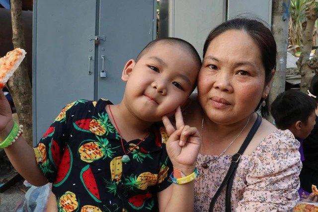 Bà Liên và cháu Mạnh trong tiệc sinh nhật miễn phí. ẢNH: UYỂN NHI