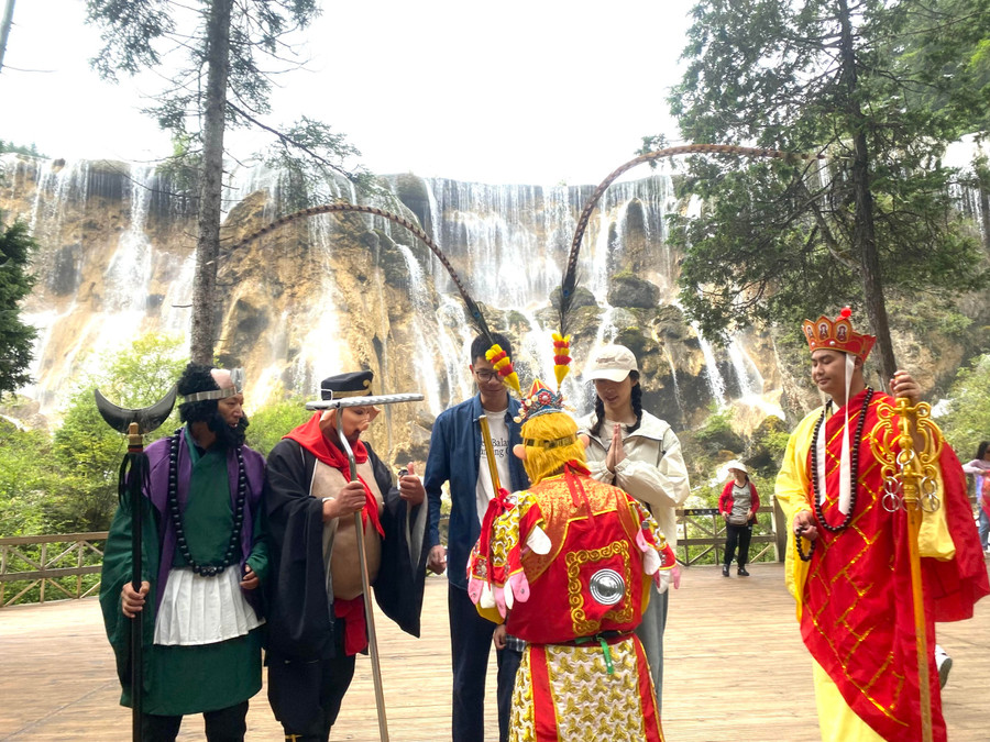 Dưới chân thác Trân Châu cao 28 m, rộng 310 m, nơi có cảnh quay đầu tiên trong bộ phim truyền hình Tây du ký, có dịch vụ chụp ảnh với nhân vật đóng thầy trò Đường Tăng. Ảnh HỨA XUYÊN HUỲNH