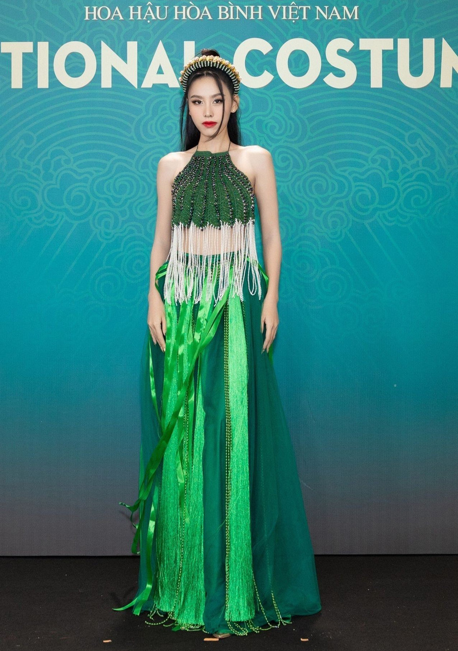 Miss International Vietnam 2023 chọn trang phục áo yếm, chân váy tứ thân cách tân. Sắc xanh giúp cô nổi bật so với dàn hoa, á hậu trên thảm đỏ.