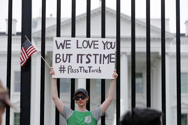 Một thanh niên giơ tấm biển kêu gọi Tổng thống Biden chuyển ngọn đuốc của đảng cho người khác. (Ảnh: Reuters) Một thanh niên giơ tấm biển kêu gọi Tổng thống Biden chuyển ngọn đuốc của đảng cho người khác. (Ảnh: Reuters)