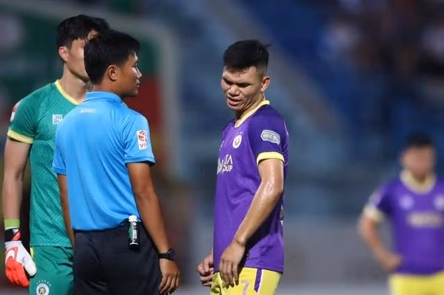 Trọng tài Nguyễn Mạnh Hải nghe tham vấn của VAR về tình huống để bóng chạm tay của Xuân Mạnh. Ảnh: MINH TÚ