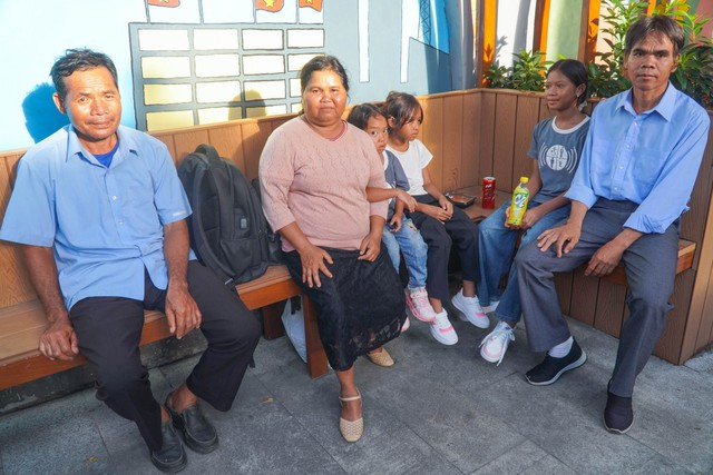 Trong lúc chờ con làm thủ tục nhập học, bà Ka In (ở giữa) và các thành viên khác ngồi nghỉ ngơi và đi tham quan trường.