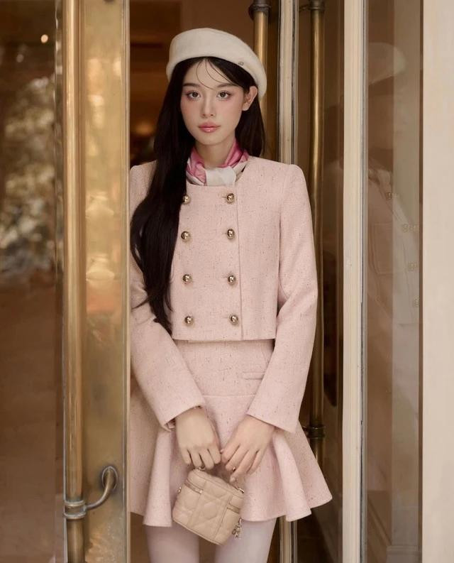Sở hữu màu sắc ngọt ngào và tươi mới, bộ trang phục gồm áo khoác kiểu hoàng gia và chân váy xòe sẽ biến người mặc trở thành một nàng công chúa với diện mạo vô cùng thu hút. Bằng thiết kế đặc biệt được kết hợp giữa dáng áo khoác lửng cùng chân váy đuôi cá tạo cảm giác trẻ trung và năng động. Điều làm bộ đồ trở nên nổi bật còn nằm ở phụ kiện cúc tròn to bản màu vàng kim loại sang chảnh và bắt mắt, vừa mang đến sự nữ tính vốn có, vừa xen lẫn chút cá tính, tinh nghịch