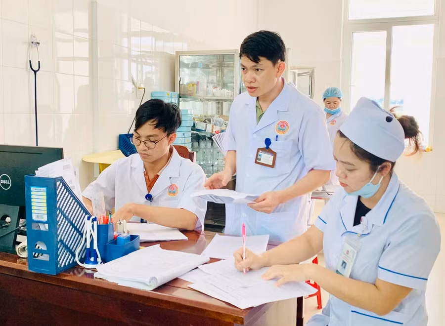 Bác sĩ Nguyễn Xuân Trung cùng các đồng nghiệp nghiên cứu hồ sơ bệnh án để tìm phương án điều trị hiệu quả nhất cho người bệnh. Ảnh: Như Nguyện