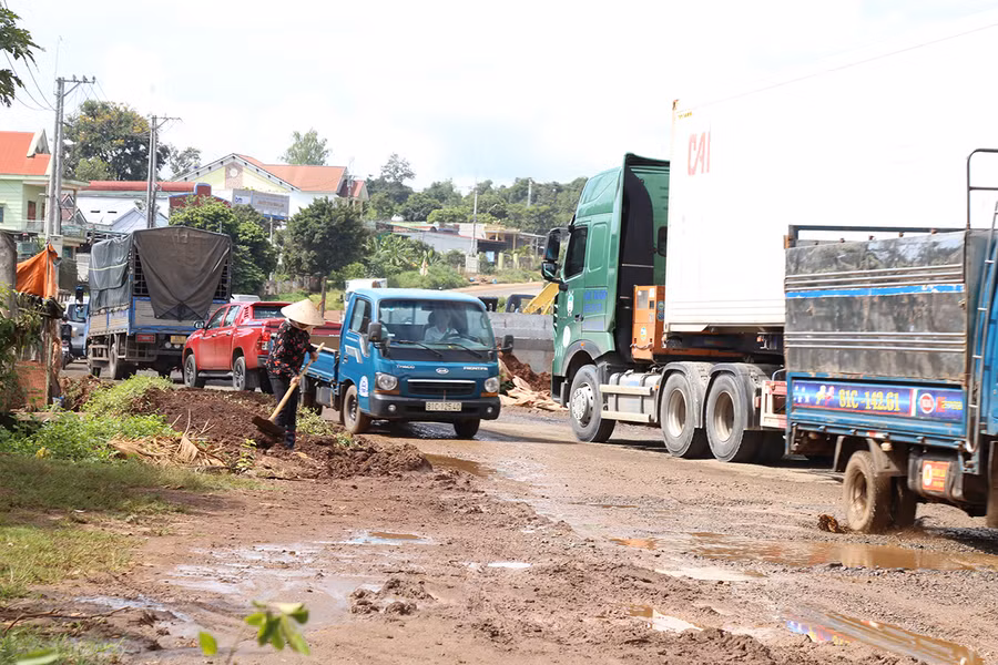 Đơn vị thi công quốc lộ 19 (đoạn qua huyện Đak Đoa) để lại các ụ đất lớn chắn trước cổng nhà, người dân phải san gạt mới có lối đi. Ảnh: Minh Phương