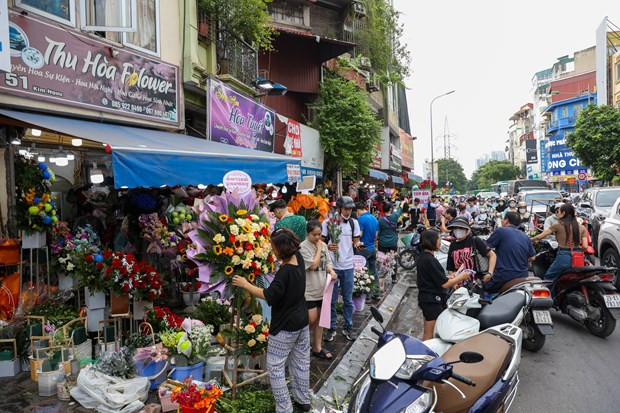 Từ sớm, không khí mua sắm hoa tươi đã tấp nập trên các tuyến phố. (Ảnh: Minh Hiếu/Vietnam+) Từ sớm, không khí mua sắm hoa tươi đã tấp nập trên các tuyến phố. (Ảnh: Minh Hiếu/Vietnam+)
