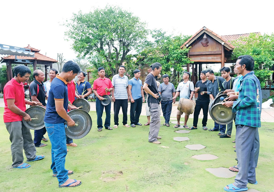 Nhà nghiên cứu Bùi Trọng Hiền lắng nghe âm thanh cồng chiêng sau khi các nghệ nhân Jrai thực hành chỉnh sửa theo phương pháp do ông truyền đạt. Ảnh: H.N Nhà nghiên cứu Bùi Trọng Hiền lắng nghe âm thanh cồng chiêng sau khi các nghệ nhân Jrai thực hành chỉnh sửa theo phương pháp do ông truyền đạt. Ảnh: H.N