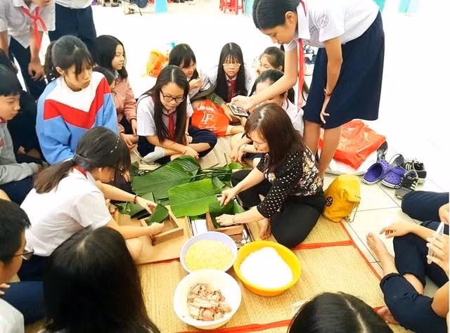Học sinh và giáo viên cùng nhau gói bánh chưng. Ảnh: Bảo Hân