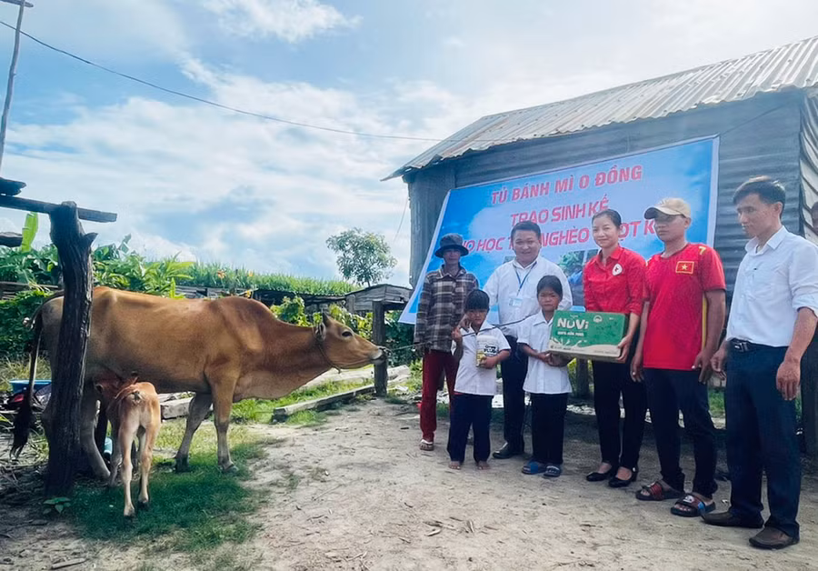 Thầy Vũ Văn Tùng (thứ 2 từ trái sang) cùng Hội Chữ thập đỏ huyện Ia Pa, Ban Giám hiệu Trường Tiểu học và THCS Đinh Núp trao tặng bò cho em Đinh Tháng. Ảnh: N.H