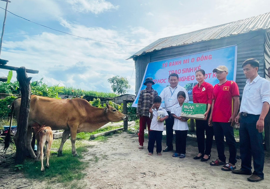 Thầy Vũ Văn Tùng (thứ 2 từ trái sang) cùng Hội Chữ thập đỏ huyện Ia Pa, Ban Giám hiệu Trường Tiểu học và THCS Đinh Núp trao tặng bò cho em Đinh Tháng. Ảnh: N.H
