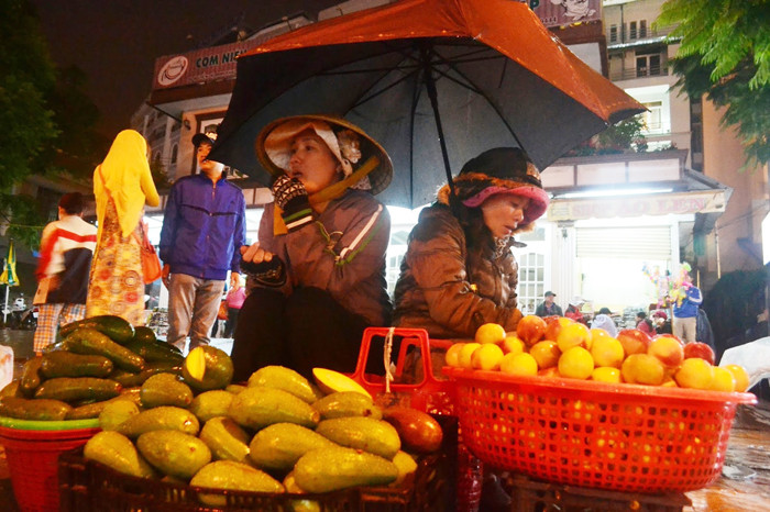 Người buôn bán nhỏ lẻ ở “chợ âm phủ” co ro trong đêm mưa. Người buôn bán nhỏ lẻ ở “chợ âm phủ” co ro trong đêm mưa.