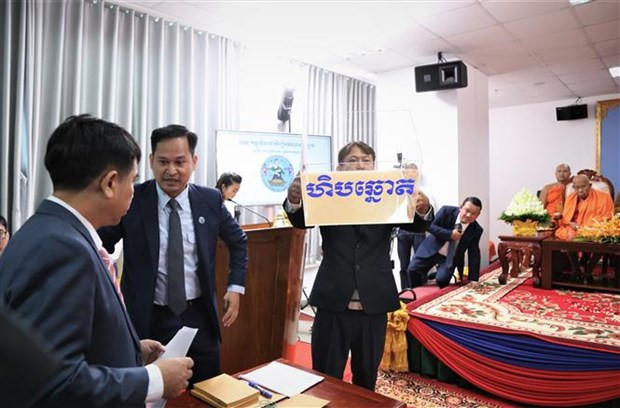 Các quan chức và nhân viên Ủy ban Bầu cử Quốc gia Campuchia giới thiệu thùng phiếu tại lễ bốc thăm. (Ảnh: Huỳnh Thảo/TTXVN)