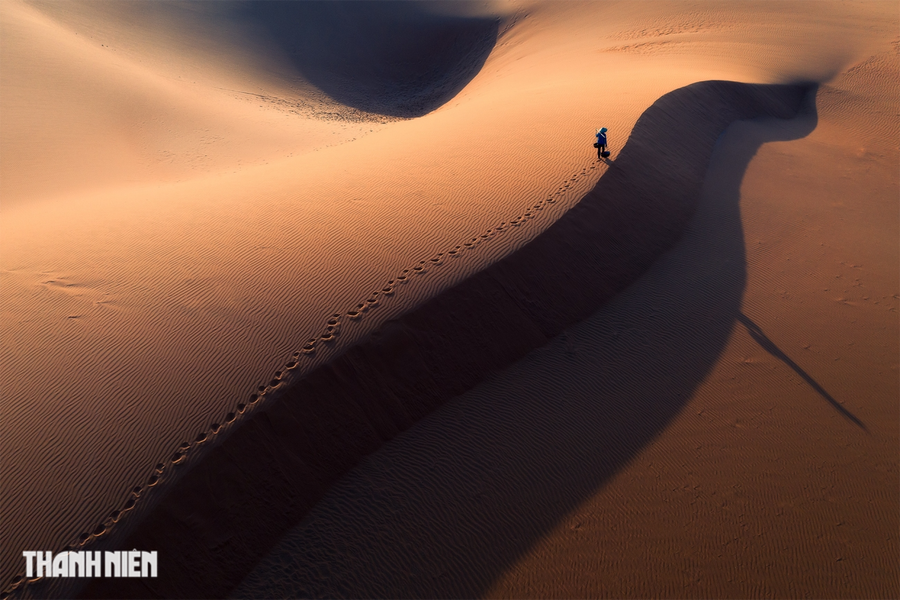 Bộ ảnh The Strength of Solitude (tạm dịch Sự cô độc, điểm nhấn ấn tượng mạnh giữa phong cảnh) của Cao Kỳ Nhân. Tác giả khai thác ưu điểm &quot;sự cô độc&quot;, hàm ý mang lại hữu ích cho con người trong cuộc sống là độc lập hơn, sáng tạo hơn và tạo niềm tin mạnh mẽ vào bản thân. Trên ảnh là Mẹ gánh ngang đồi cát Mũi Né - Bình Thuận.