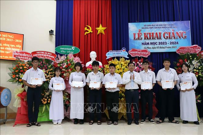 Thầy giáo Lê Chí Nguyễn, Hiệu trưởng Trường THPT Chuyên Phan Ngọc Hiển trao học bổng cho các học sinh đạt điểm thủ khoa tuyển sinh vào lớp 10 chuyên. Ảnh: Kim Há/TTXVN Thầy giáo Lê Chí Nguyễn, Hiệu trưởng Trường THPT Chuyên Phan Ngọc Hiển trao học bổng cho các học sinh đạt điểm thủ khoa tuyển sinh vào lớp 10 chuyên. Ảnh: Kim Há/TTXVN