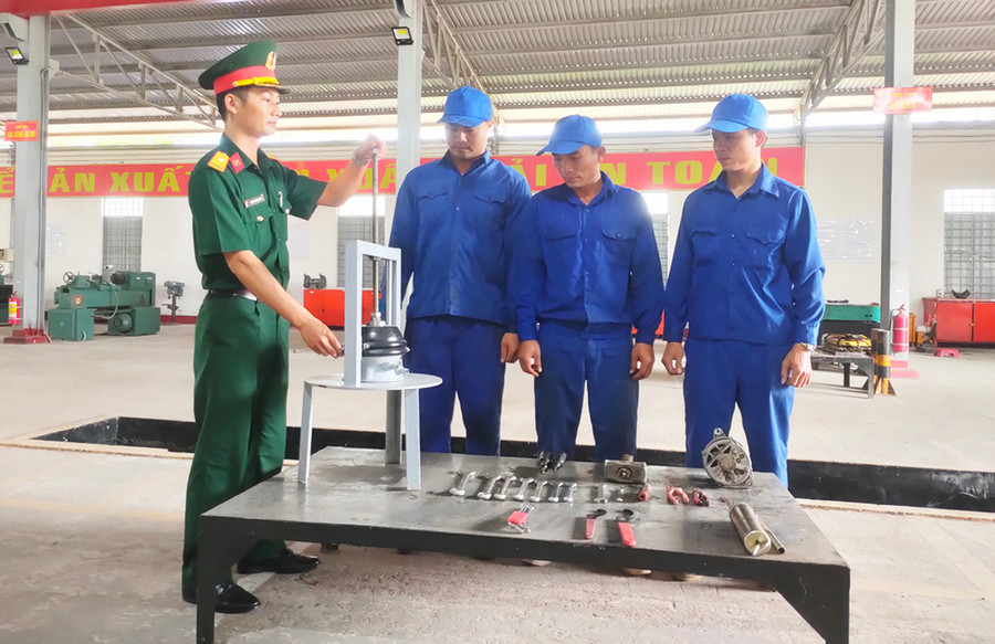Thiếu tá Trương Ngọc Chung giới thiệu với thợ kỹ thuật của đơn vị về sáng kiến “Giá van tháo bầu phanh lốc kê xe ô tô”. Ảnh: V.H Thiếu tá Trương Ngọc Chung giới thiệu với thợ kỹ thuật của đơn vị về sáng kiến “Giá van tháo bầu phanh lốc kê xe ô tô”. Ảnh: V.H