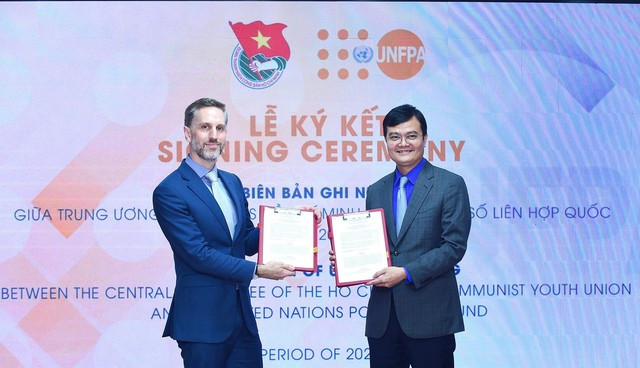Bước tiến quan trọng trong việc phối hợp giữa T.Ư Đoàn và UNFPA - Ảnh 3. Anh Bùi Quang Huy và ông Matthew David Jackson trao đổi văn bản ký kết hợp tác giữa hai bên. Ảnh: XUÂN TÙNG