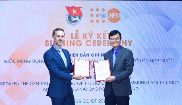 Anh Bùi Quang Huy và ông Matthew David Jackson trao đổi văn bản ký kết hợp tác giữa hai bên. Ảnh: XUÂN TÙNG